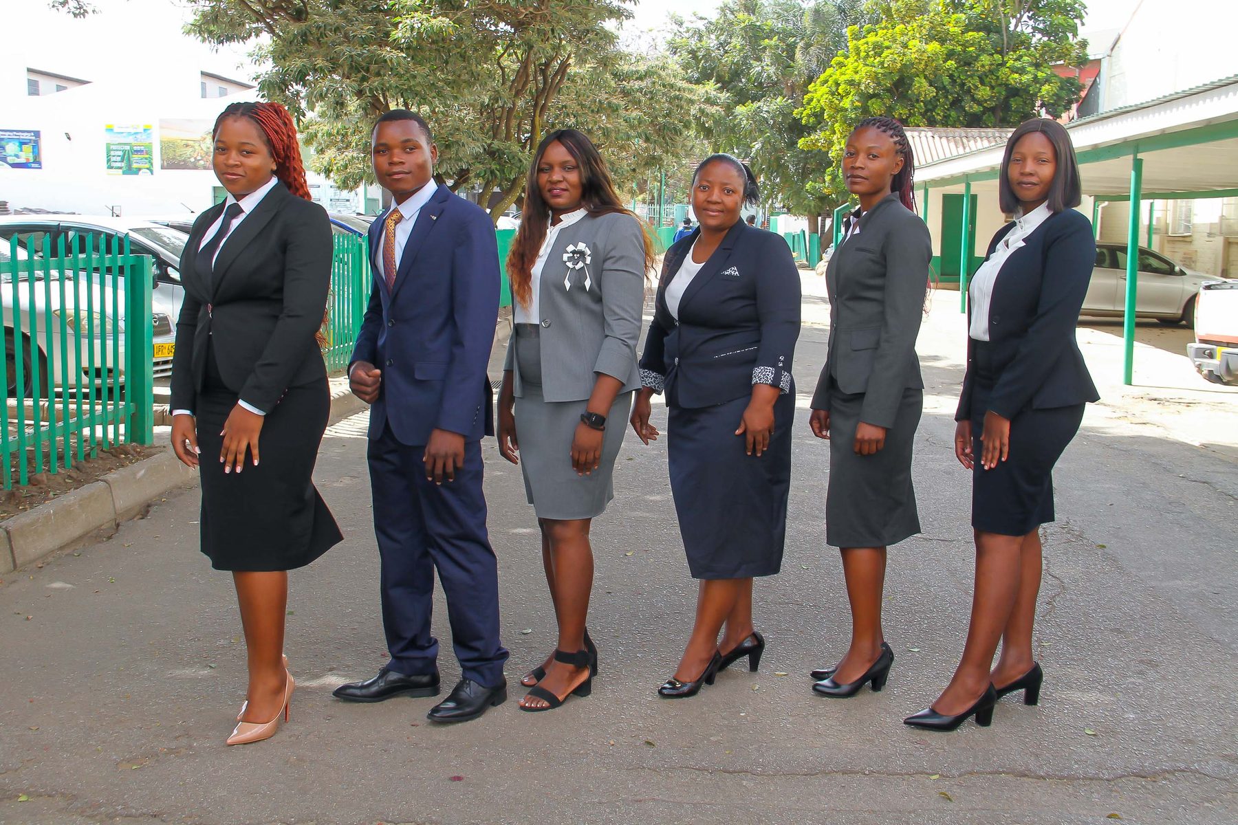 A NECST corporate team dressed in tailored navy and grey business suits