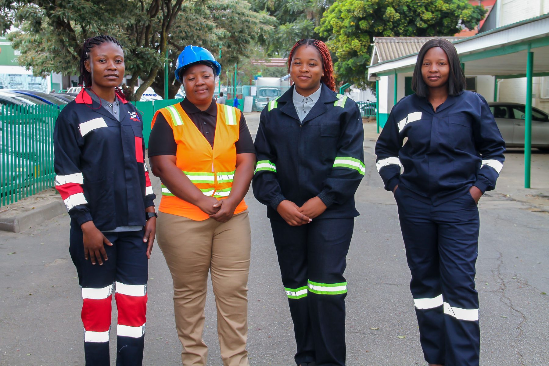 Four women wearing NECST industrial workwear coveralls and a hi-visibility vest